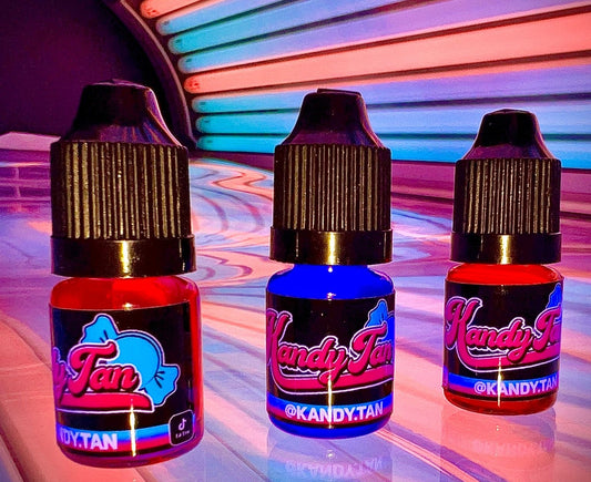 3 pack of  pink bubblegum, raspery and candyfloss flavoured tanning drops sitting on a coloured sun bed with Kandytan logo 